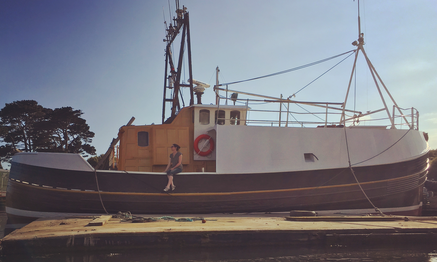 Lisa sitting on the side of the fishing trawler house boat Albacore