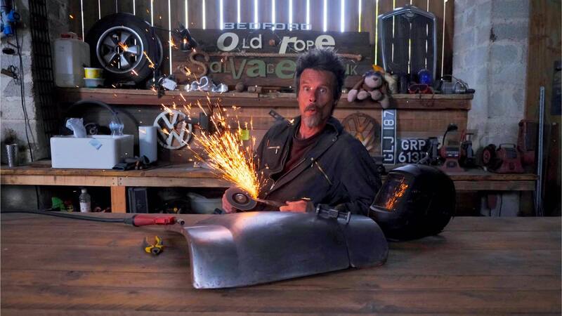 Man creating sparks with a grinding disk inside a workshop setting