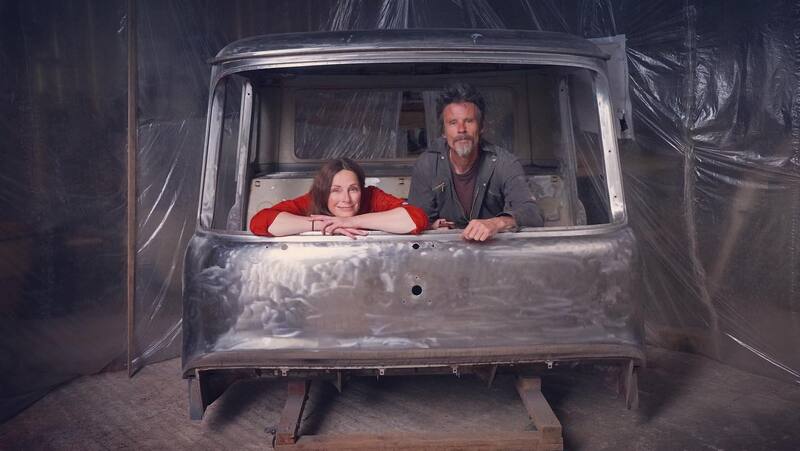 Man and woman with a Bedford cab in bare metal