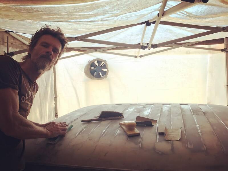 Man in workshop sanding the roof of a Bedford truck cab