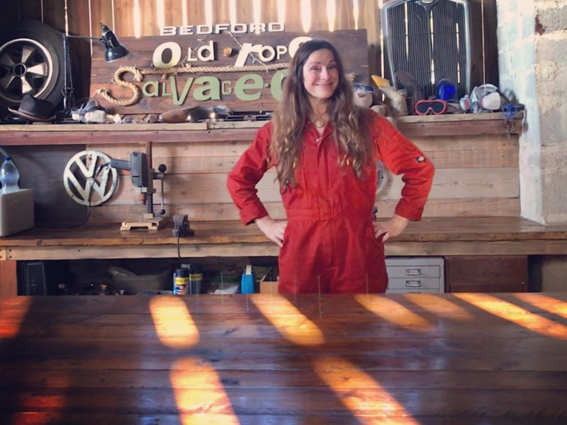 Woman in orange overalls in a workshop with Old Rope Salvage sign in the background