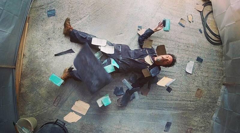 Man in overalls lying on floor surrounded by used sanding blocks