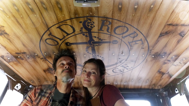 Man and woman in a Bedford cab with Old Rope Salvage logo on wooden headliner