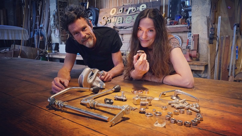 Man and woman at a workbench with shiny electro plated car parts