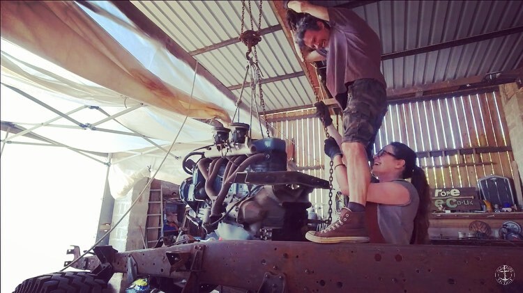 Man and woman winching out an old engine from a Bedford truck chassis