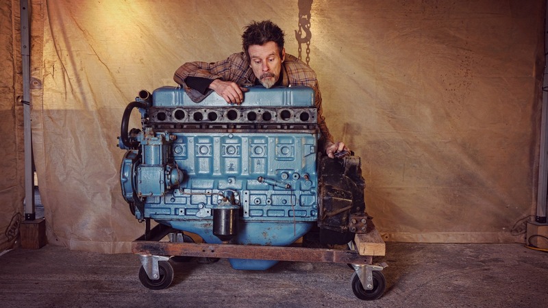 Man with a big petrol engine from an old Bedford truck