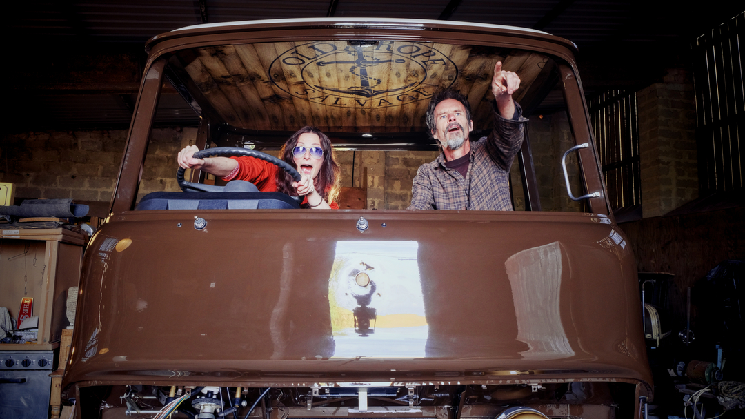 Man and woman inside the restored cab of a 1975 Bedford truck