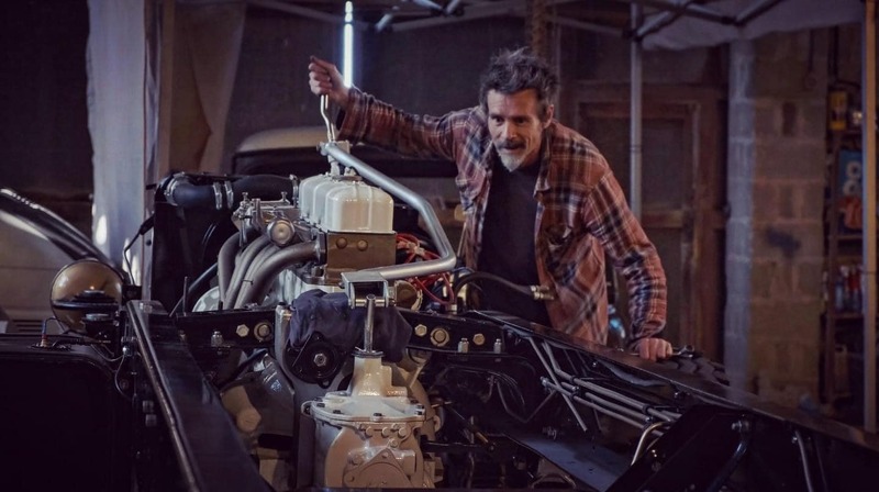 Man adjusting a restored gearbox in a 1970s restored Bedford truck