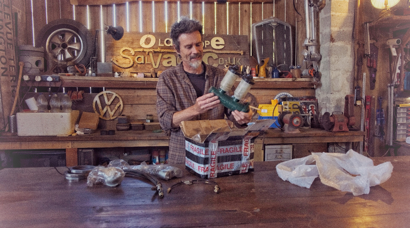 Man in workshop unpacking a master cylinder for a Bedford truck