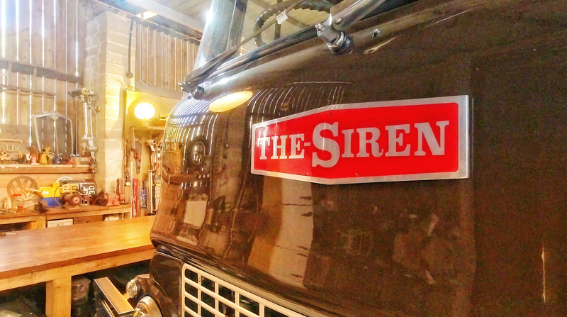 Close up of The Siren name badge on the front of a brown painted restored Bedford truck
