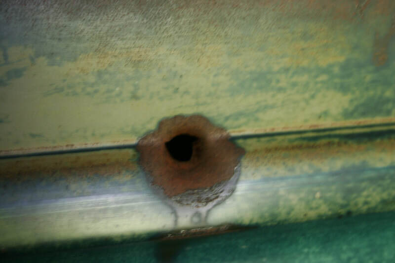 Bullet hole in the side of old Ford truck