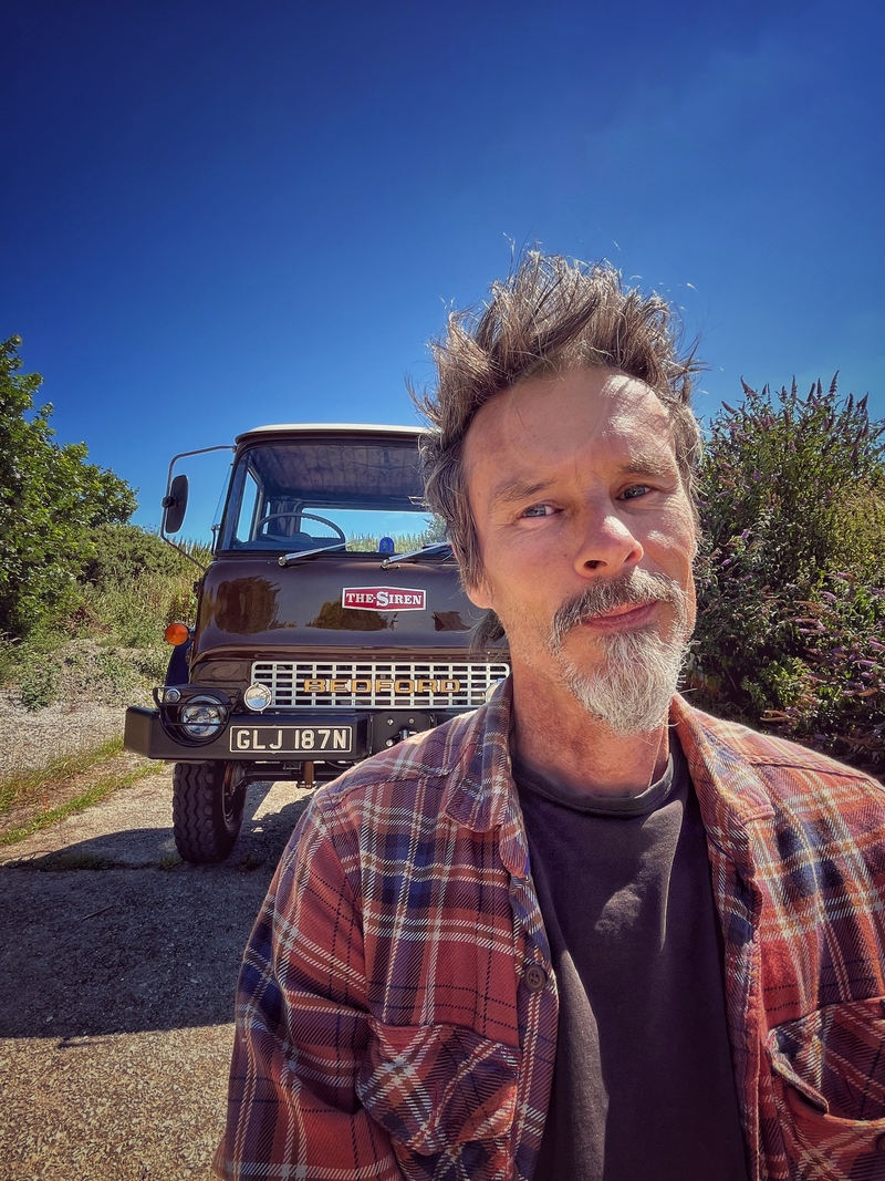 Man standing outside in front of a Bedford truck